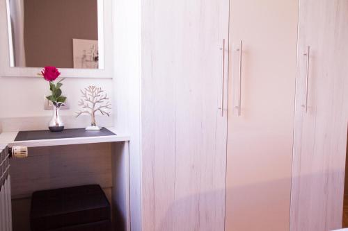 a room with a white cabinet and a vase with a flower at Apartments Zlatko & Mira Dorcic in Baška