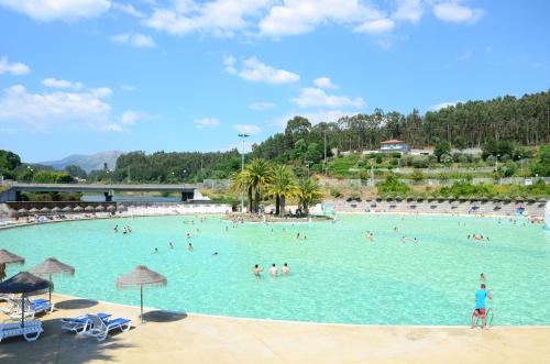a group of people in a large swimming pool at Praia das Rocas Bungalows in Castanheira de Pêra