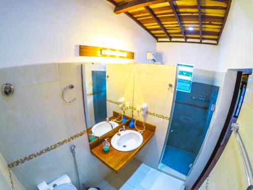 a bathroom with a sink and a shower at Pousada Oasis in Pipa