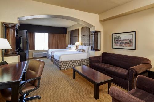 a hotel room with a bed and a living room at Radisson Hotel El Paso Airport in El Paso