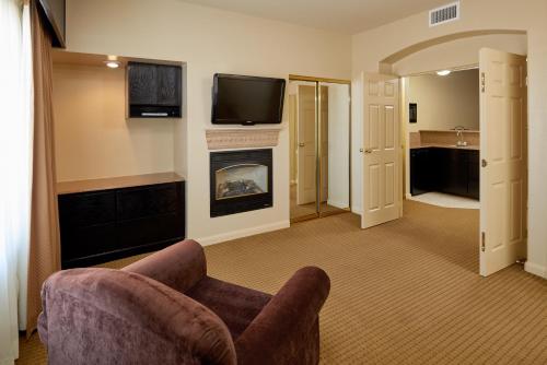 a living room with a chair and a fireplace at Radisson Hotel El Paso Airport in El Paso