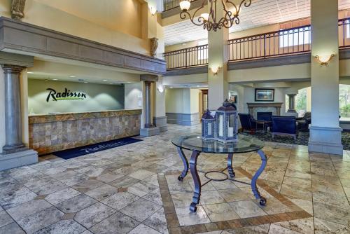a lobby with a table in the center of a building at Radisson Hotel El Paso Airport in El Paso
