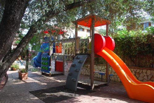 un parque infantil con un tobogán naranja en un parque en Camping Villaggio B&B Saline, en Palinuro