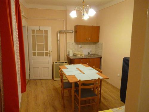 a kitchen with a table and chairs in a room at Pallósi Ház "A" in Sárvár