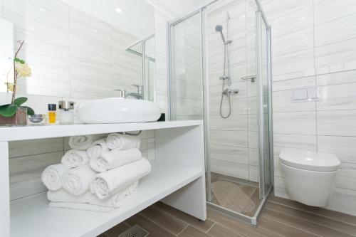 a white bathroom with a sink and a shower at Apartments Soho in Trogir