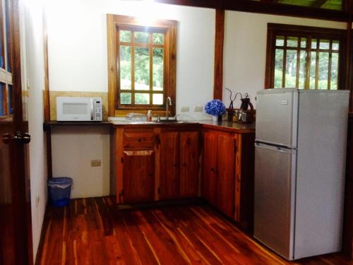 a kitchen with wooden floors and a refrigerator and a sink at Lemon House Monteverde in Monteverde Costa Rica