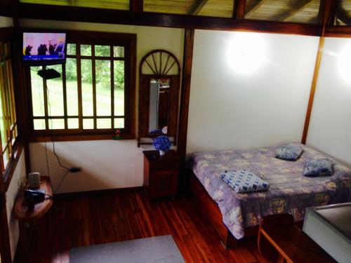 a bedroom with a bed and a tv in it at Lemon House Monteverde in Monteverde Costa Rica
