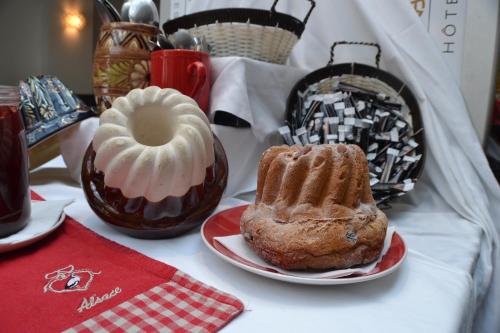 a table with two pastries on plates on a table at Hotel Primo Colmar Centre in Colmar