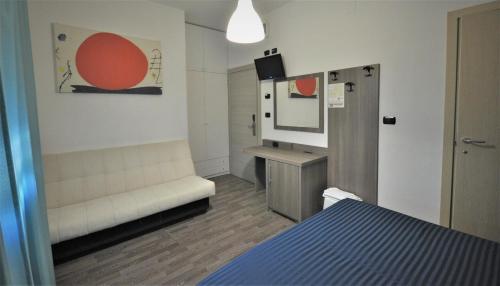 a room with a bed and a couch and a mirror at Hotel Miramare Dipendenza in Pineto