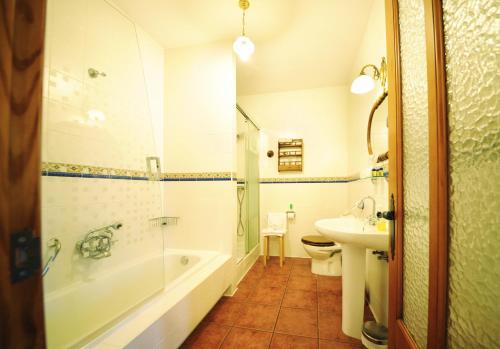 ein Badezimmer mit einer Badewanne, einem WC und einem Waschbecken in der Unterkunft Hotel Mar de Queo in Carballo