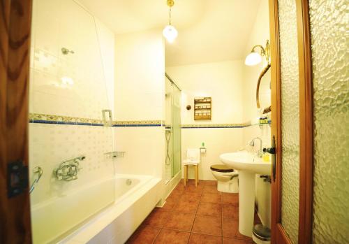 a bathroom with a tub and a toilet and a sink at Hotel Mar de Queo in Carballo