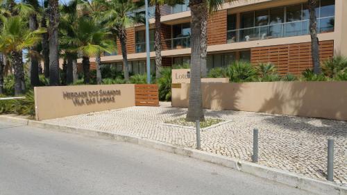 a building with a sign in front of a street at Apartamento Salgados Beach in Albufeira