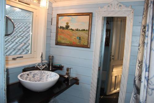 La salle de bains est pourvue d'un lavabo blanc et d'une fenêtre. dans l'établissement Bergen Sentrum Apartment, à Bergen