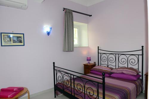 a bedroom with a black bed with purple sheets at Appartamento La Corallina in Positano
