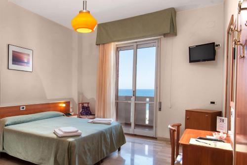 a bedroom with a bed and a large window at Hotel Continental Fano in Fano