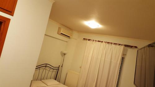 1 dormitorio con 1 cama y cortina de ducha blanca en ALEXANDER Rooms, en Nauplia