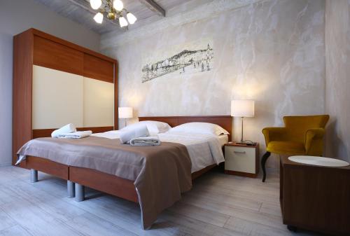 1 dormitorio con 1 cama grande y 1 silla amarilla en Luxury Lidija Rooms, en Split