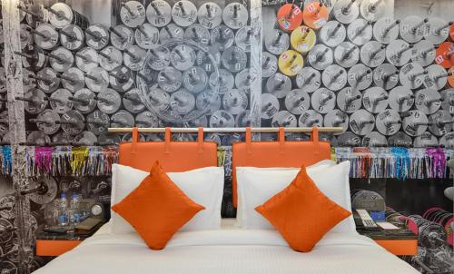 a room with a bed with orange and white pillows at Regenta Central Antarim Ahmedabad in Ahmedabad