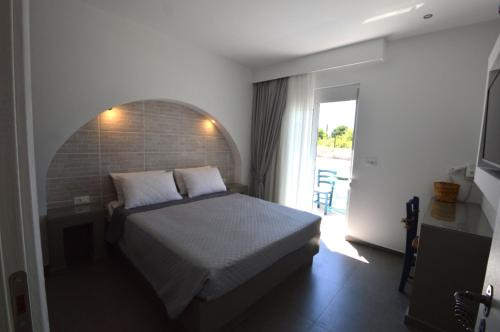 a bedroom with a bed and a large window at Kostas Studios in Faliraki