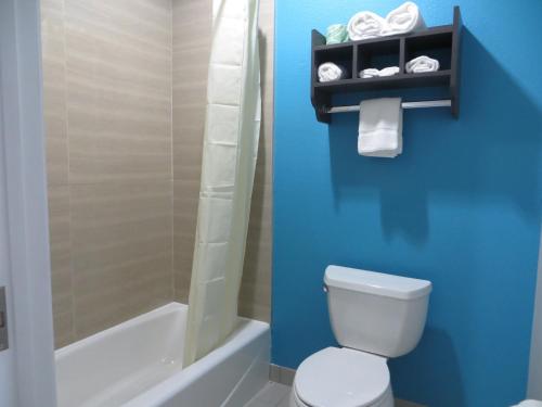 a bathroom with a toilet and a shower and a sink at Haven Inn & Suites willowbrook in Houston