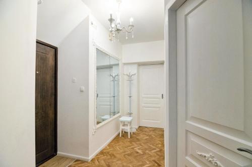 un couloir avec un miroir et une porte blanche dans l'établissement Stylish apartment. Heart of the city, à Lviv