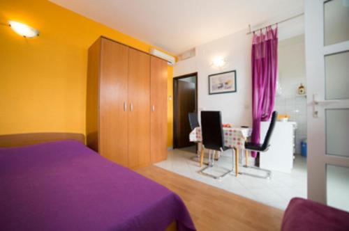 - une chambre avec un lit violet et un bureau dans l'établissement Apartments KK, à Celina