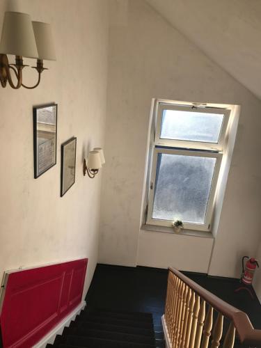 a staircase with a window and a red stair case at SmartHotel Mystique Self check-in in Bad Homburg vor der Höhe