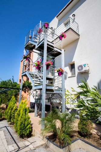 a stairwell in the side of a building with flowers at Le Zagare in Lascari