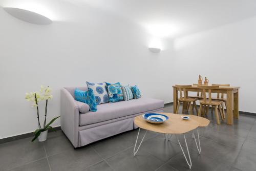 a living room with a couch and a table at San Marino Suites by Calm Collection in Fira
