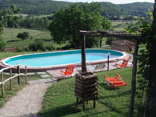 a swimming pool with a bunch of chairs around it at Il Poggiolo in Montieri