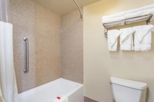 a bathroom with a toilet and a shower with towels at Days Inn by Wyndham Hershey in Hershey