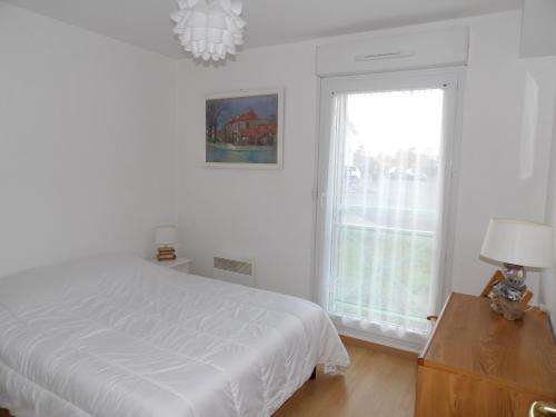 a white bedroom with a bed and a window at Clos Fleuri in Berck-sur-Mer