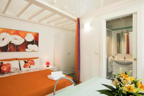 卡薩馬塞拉的住宿－Le Tre Rose di Giò，一间卧室配有橙色的床和镜子