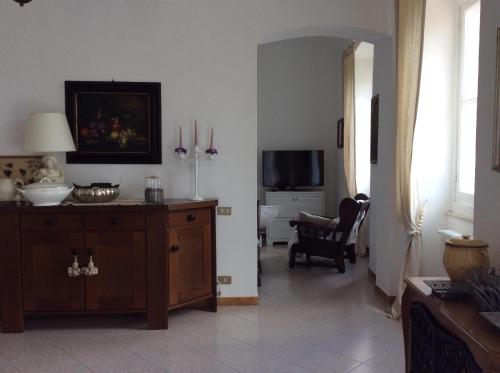 a living room with a table and a room with a chair at Aia dei Limoni in Tivegna