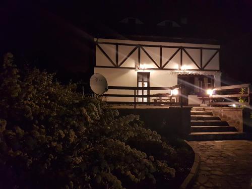 a white building with lights on it at night at La Bunica in Cisnadioara