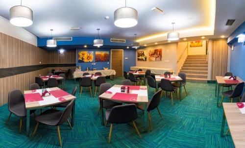 a dining room with tables and chairs and stairs at Central Hotel, Fitness and Spa in Vinica