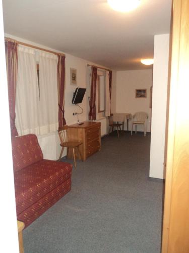 a living room with a red couch and a desk at Hotel Borest in Colfosco