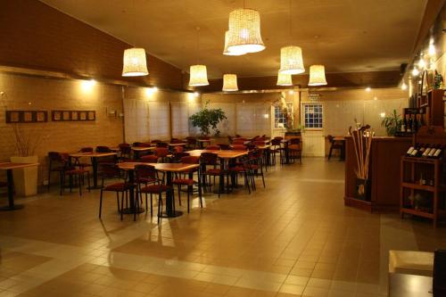 Habitación grande con mesas y sillas en un restaurante en Hotel La Fundacion, en General Roca