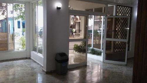 an entrance to a building with glass doors and a trash can at Hotel Costa Linda Beach Boca Chica in Boca Chica