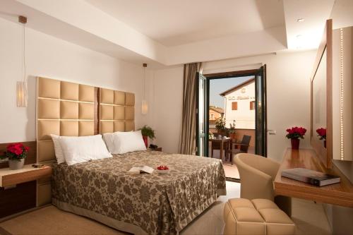 1 dormitorio con cama, mesa y escritorio en OC Hotel, en Settecamini