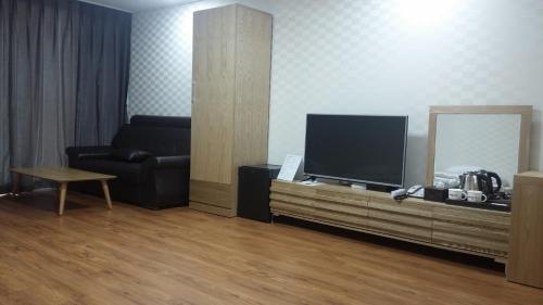 a living room with a television and a couch at Breeze Bay Hotel in Seogwipo