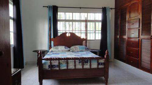 a bedroom with a bed and a large window at Posada Nativa Miss Nova in San Andrés