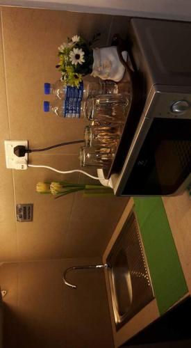 a kitchen counter with flowers on a counter top at Mama Studio Inn in Kota Bharu
