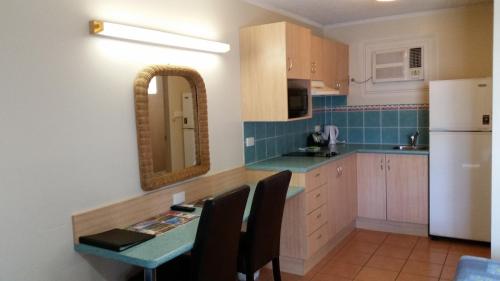 a kitchen with a table and a mirror at Cairns Gateway Resort in Cairns