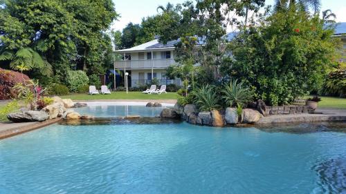 a swimming pool in front of a house at Cairns Gateway Resort in Cairns