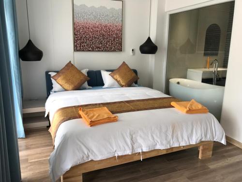 um quarto com 2 camas e uma banheira em Benny's City Hotel em Sihanoukville