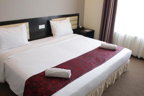 a large bed in a hotel room with two pillows at Paradise Spa Hotel in Port Dickson