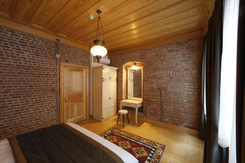 1 dormitorio con pared de ladrillo y 1 cama en una habitación en Catirga Konak Apartments, en Estambul