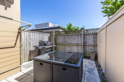 a backyard with a grill and a fence at Roma On Riccarton Motel in Christchurch