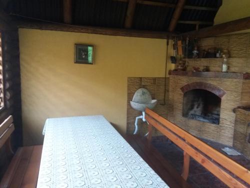 a room with a fireplace and a table and a bench at U Lyudmily in Karpaty